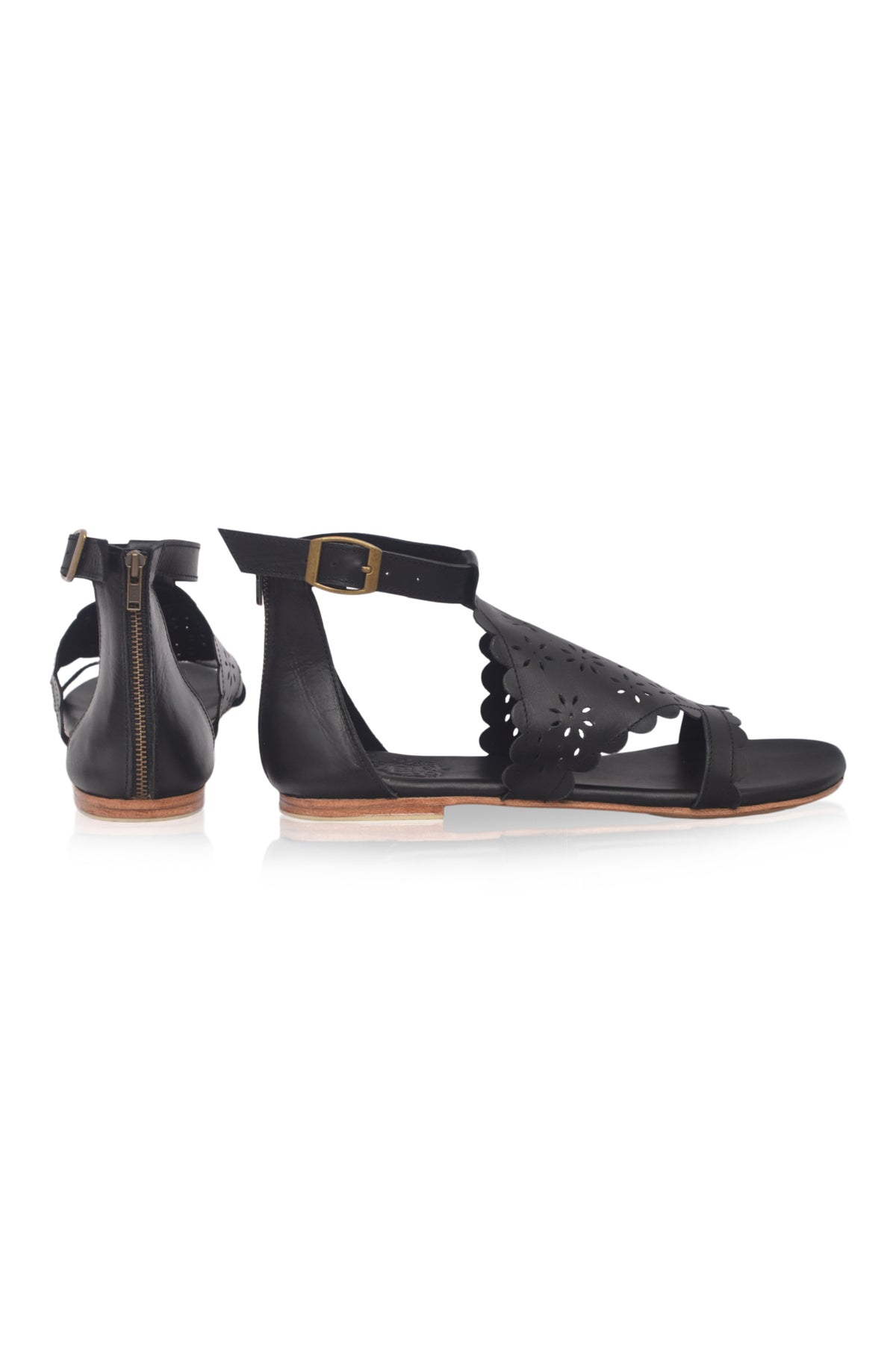 A pair of black flat sandals with cutout details, shown from the side and back angles against a white background.
