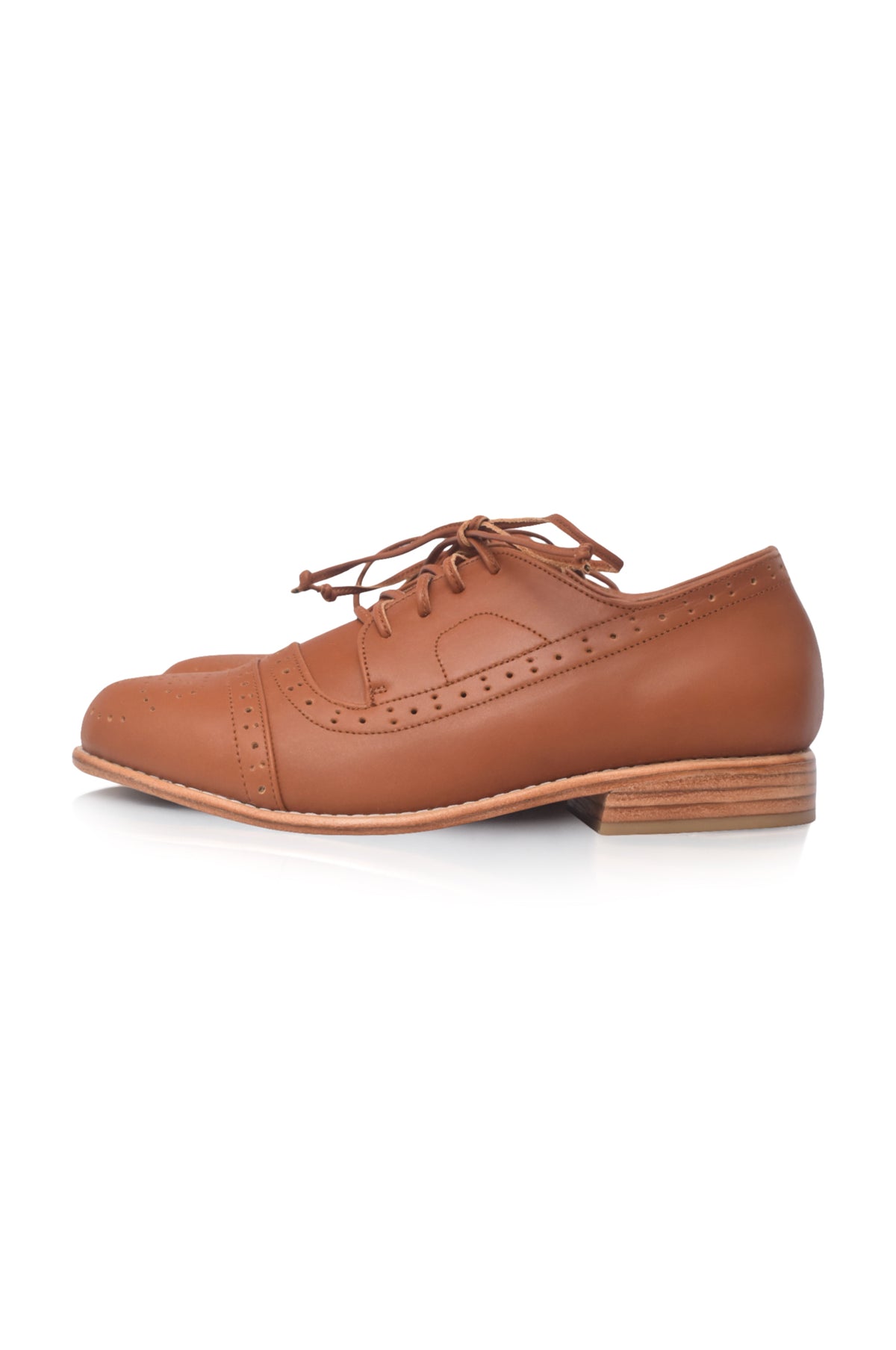 A single brown leather cap-toe oxford shoe with brogue detailing and a stacked wood-look heel, shown from a side profile on a white background.