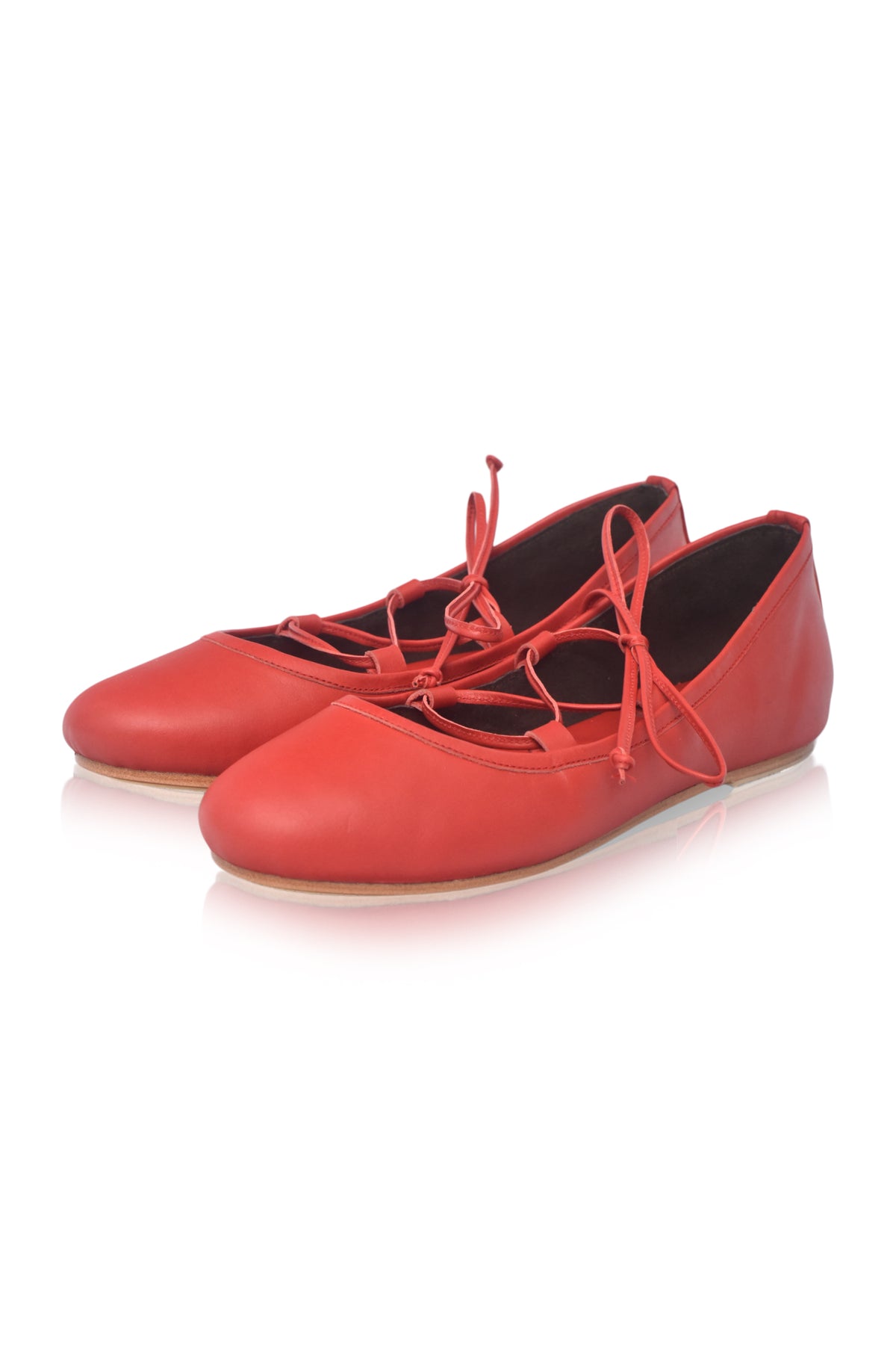 A pair of red leather lace-up flats with a low heel, displayed on a clean white background.