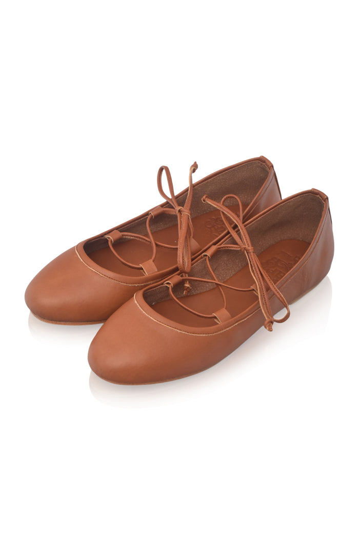 A pair of women's brown leather ballet flats with lace-up front straps and matching laces, shown on a clean white background.