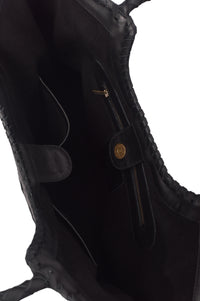 Close-up of a black leather jacket with gold buttons on a white background