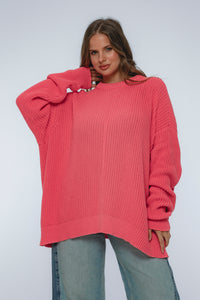 Woman wearing a pink sweater against a white background