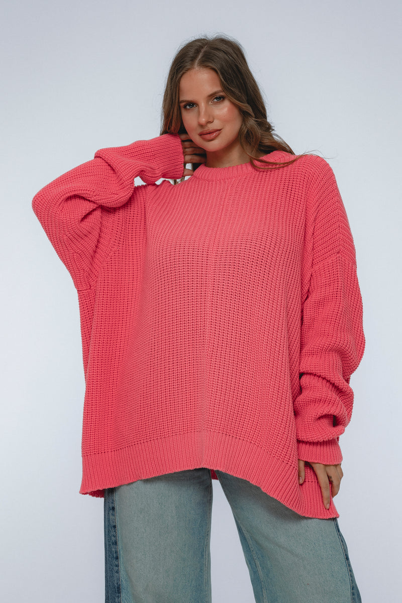 Woman wearing a pink sweater against a white background