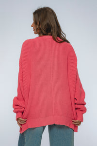 Person wearing a pink sweater on a plain background