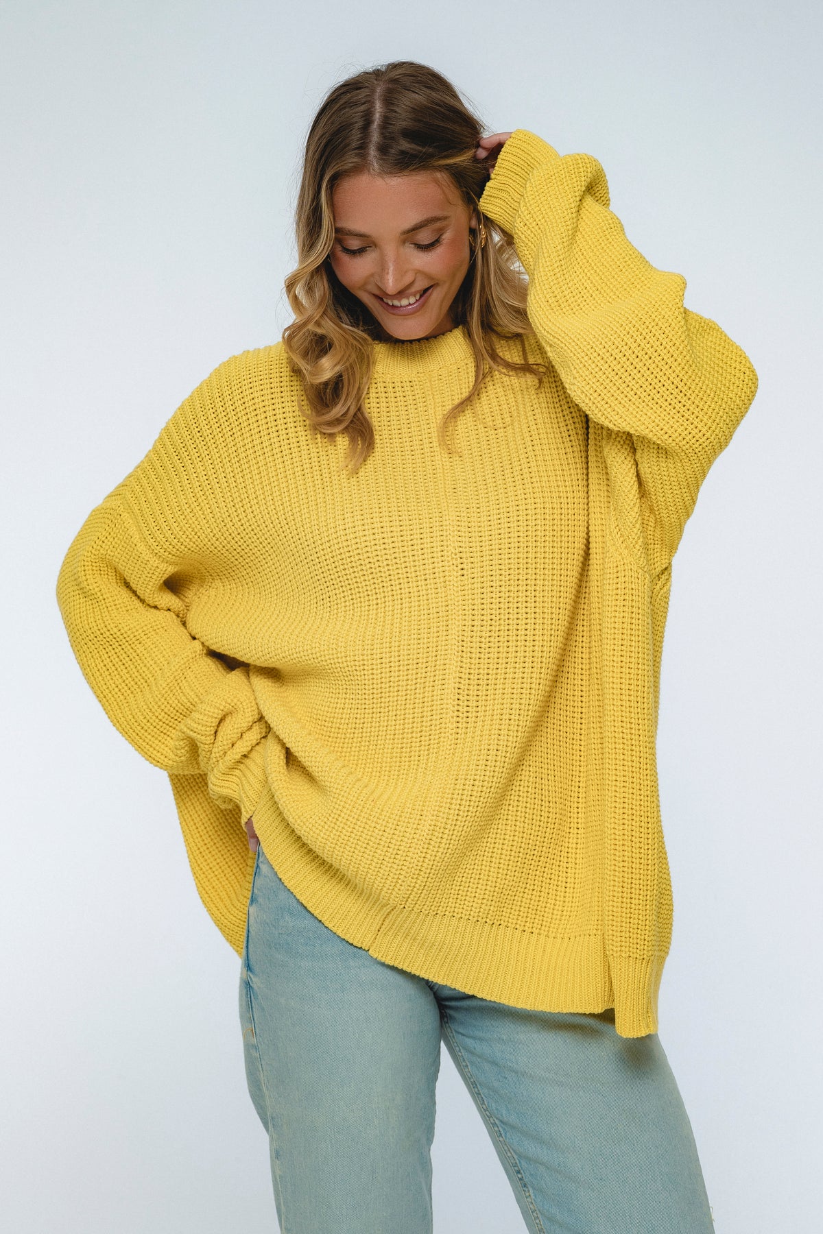 Woman wearing a yellow sweater on a white background