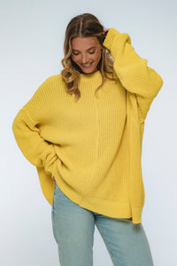 Woman wearing a yellow sweater on a white background