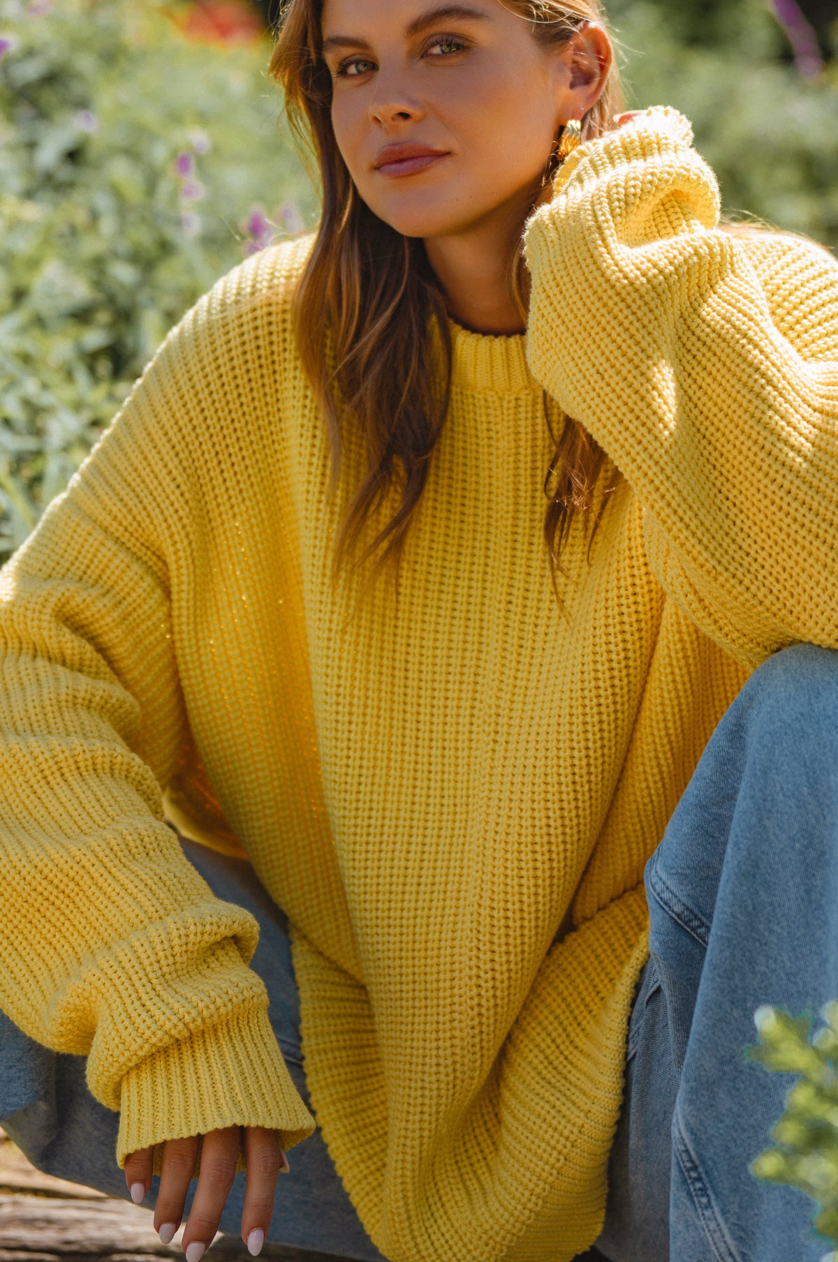 Woman wearing a yellow sweater with a blurred natural background