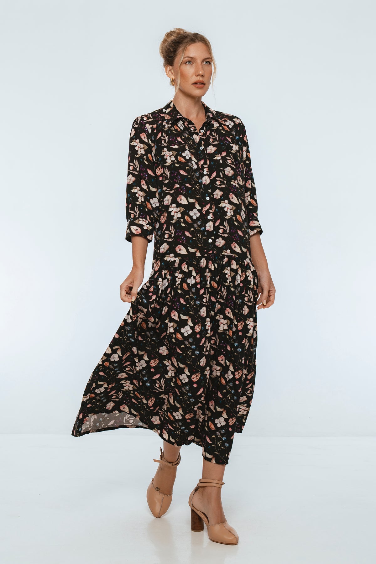 Woman wearing a black floral dress on a white background
