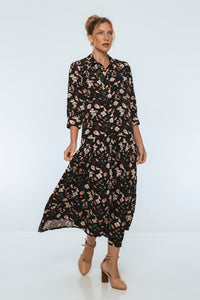 Woman wearing a black floral dress on a white background
