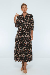Woman wearing a black floral dress on a white background