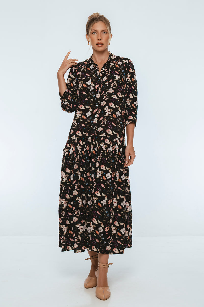 Woman wearing a black floral dress on a white background