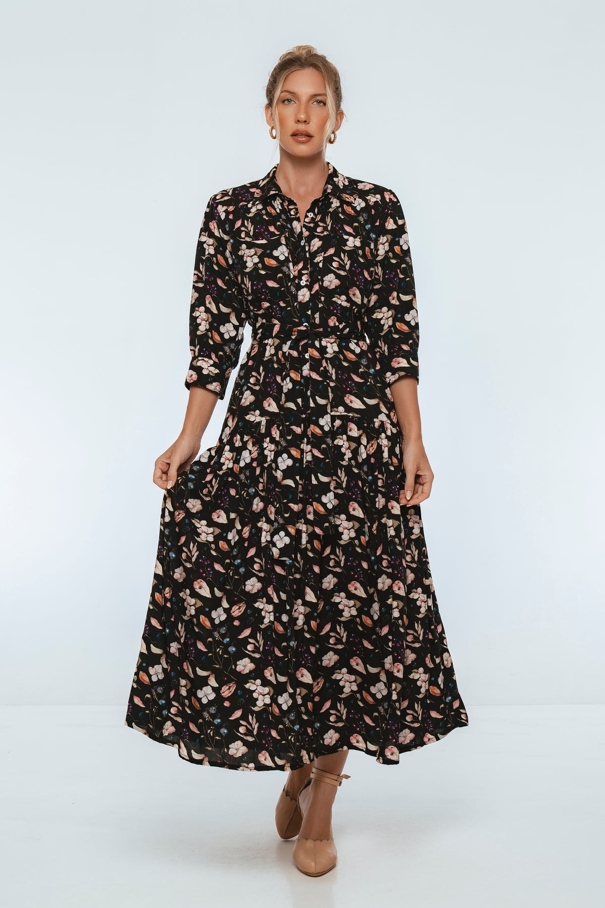 Woman wearing a black floral dress on a white background
