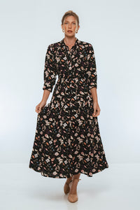 Woman wearing a black floral dress on a white background