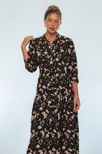 Woman wearing a floral dress against a plain background