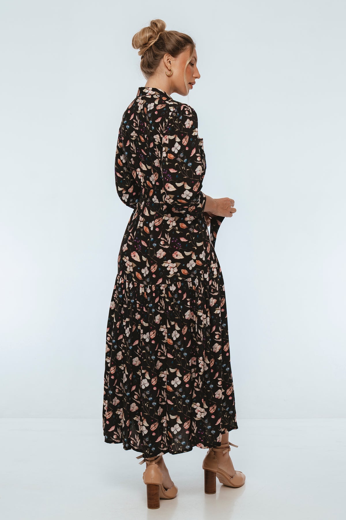 Woman wearing a black floral dress on a white background