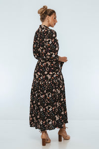Woman wearing a black floral dress on a white background
