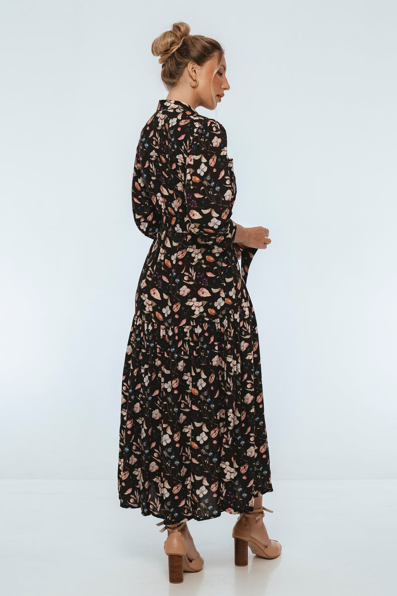 Woman wearing a black floral dress on a white background