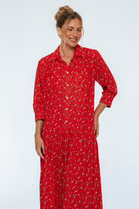 Woman wearing a red dress with a subtle pattern on a white background