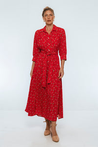 Woman wearing a red patterned dress on a white background