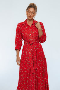 Woman wearing a red floral dress on a light gray background