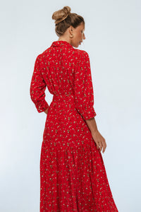 Woman wearing a red floral dress against a white background