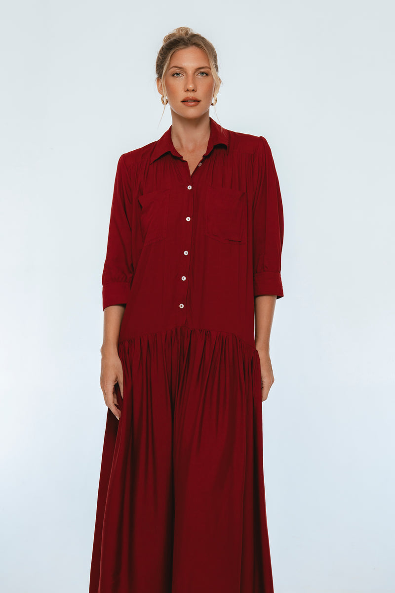 Woman wearing a long burgundy dress against a white background