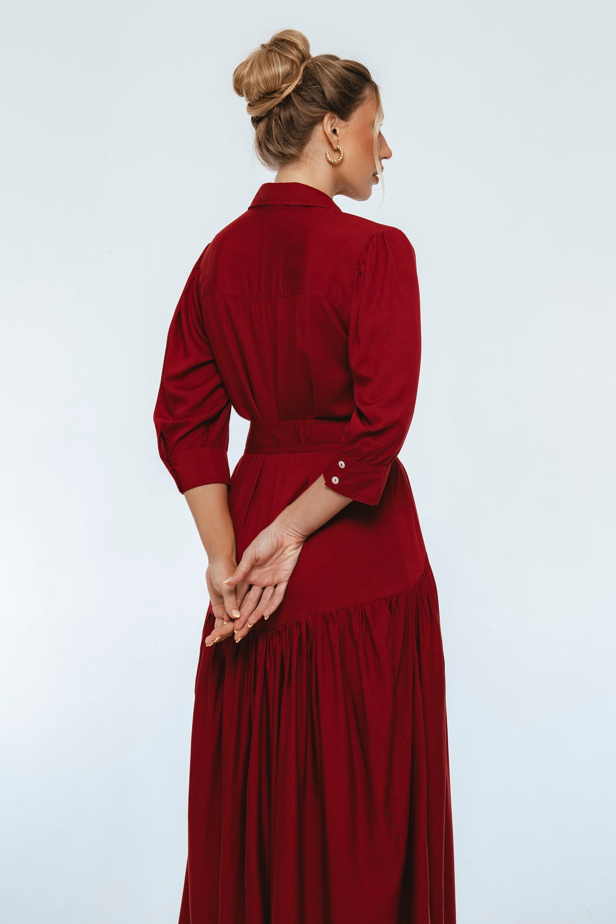 Woman wearing a long red dress against a white background