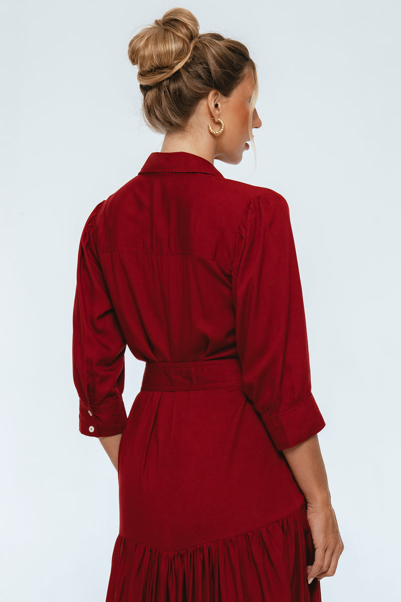 Woman wearing a burgundy dress with a plain background