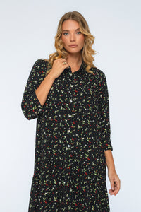 Woman wearing a black floral dress against a white background