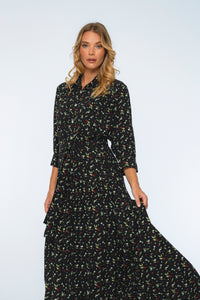 Woman wearing a black floral dress against a white background