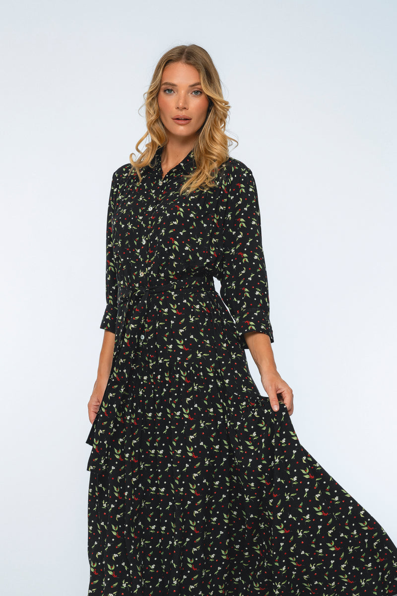Woman wearing a black floral dress against a white background