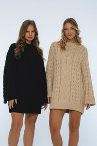 Two women wearing black and beige cable knit dresses on a white background