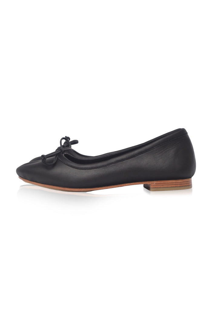 Black flat shoe with a bow on a white background