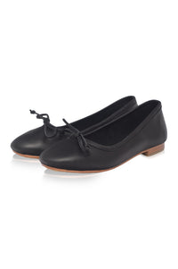 Pair of black leather shoes with a bow on a white background