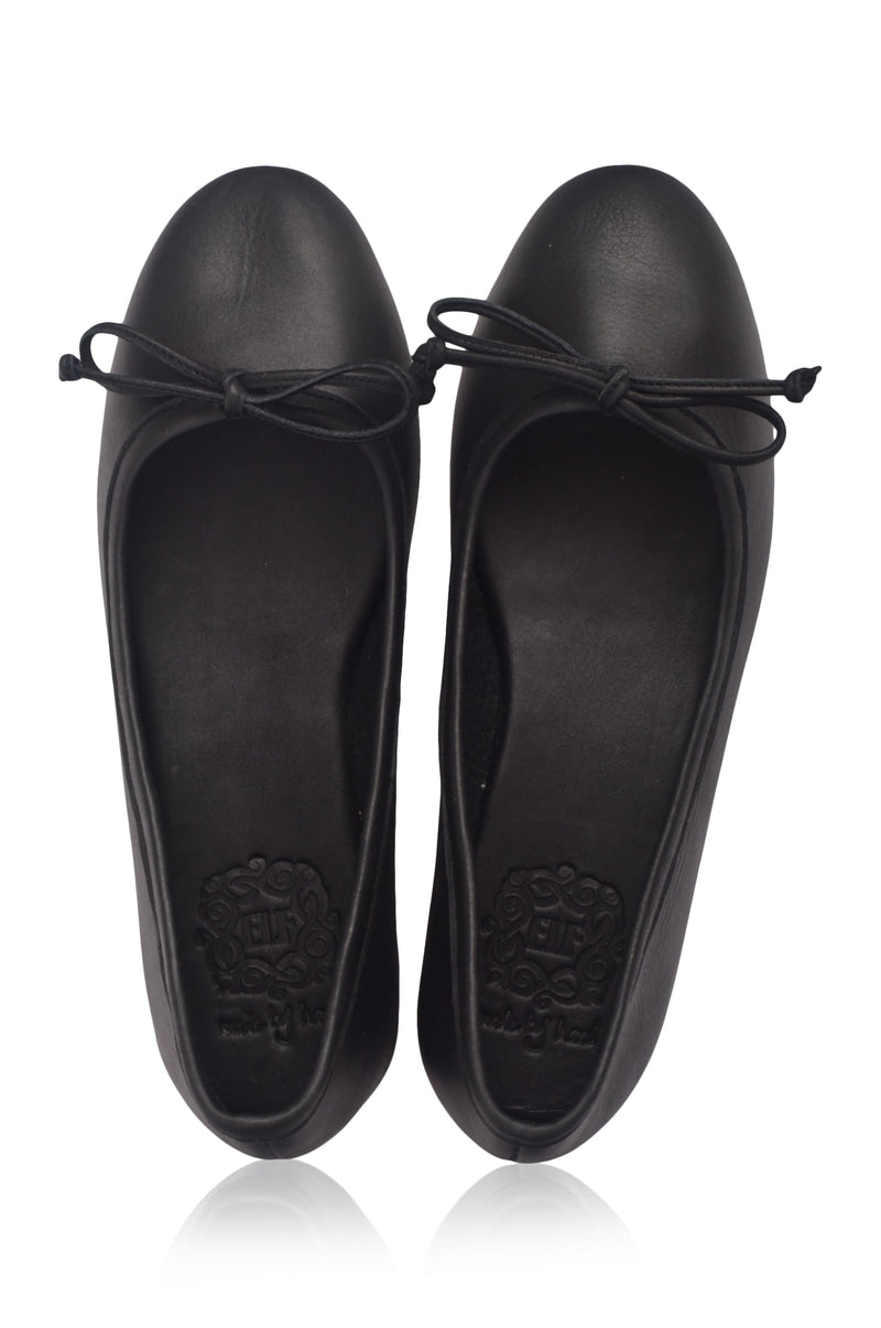 Pair of black flat shoes with bow details on a white background