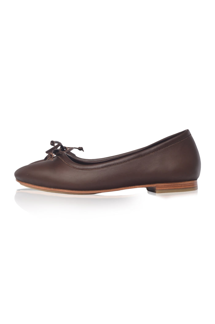 Brown flat shoe with a bow on a white background