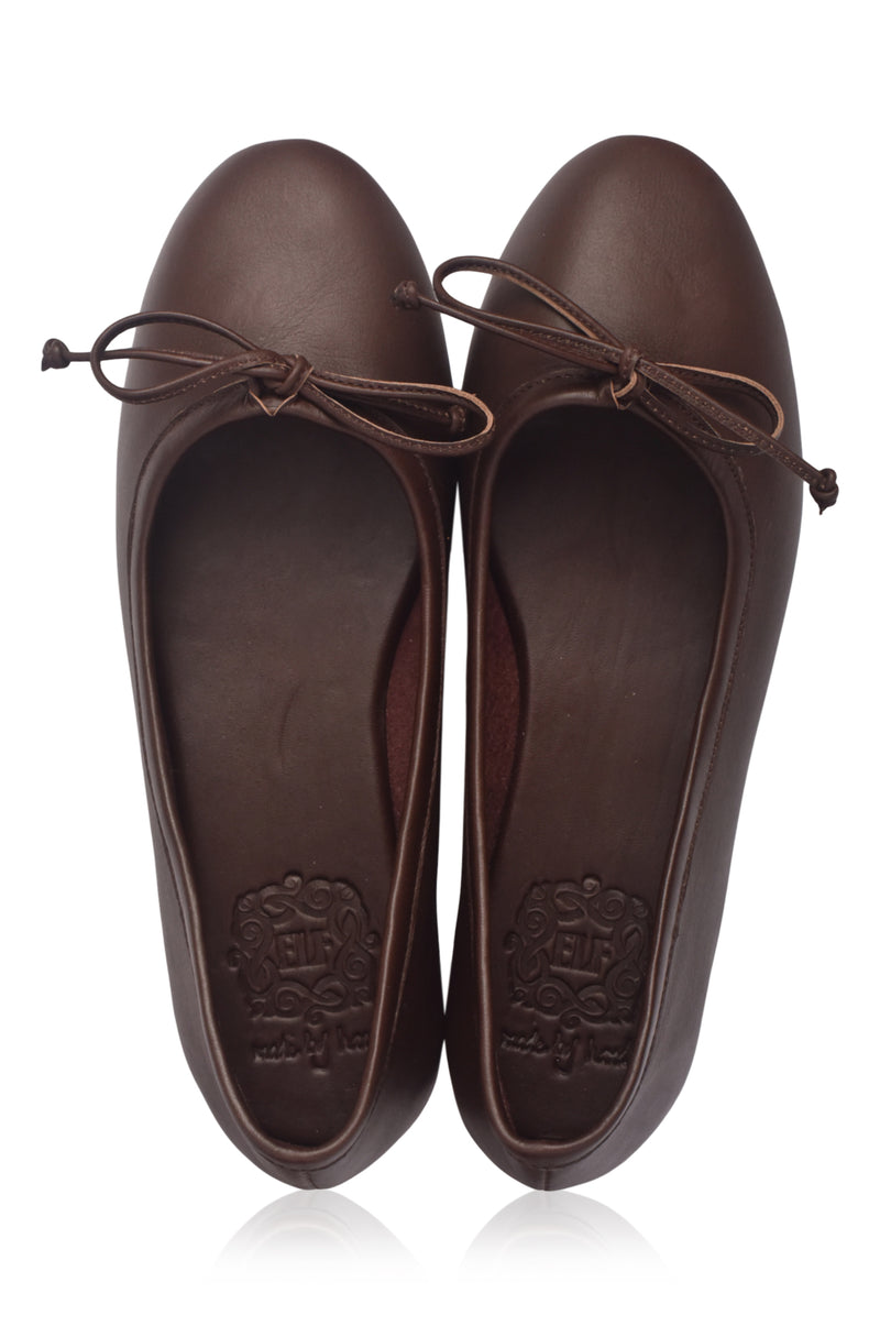 Pair of brown leather flats with bow details on a white background