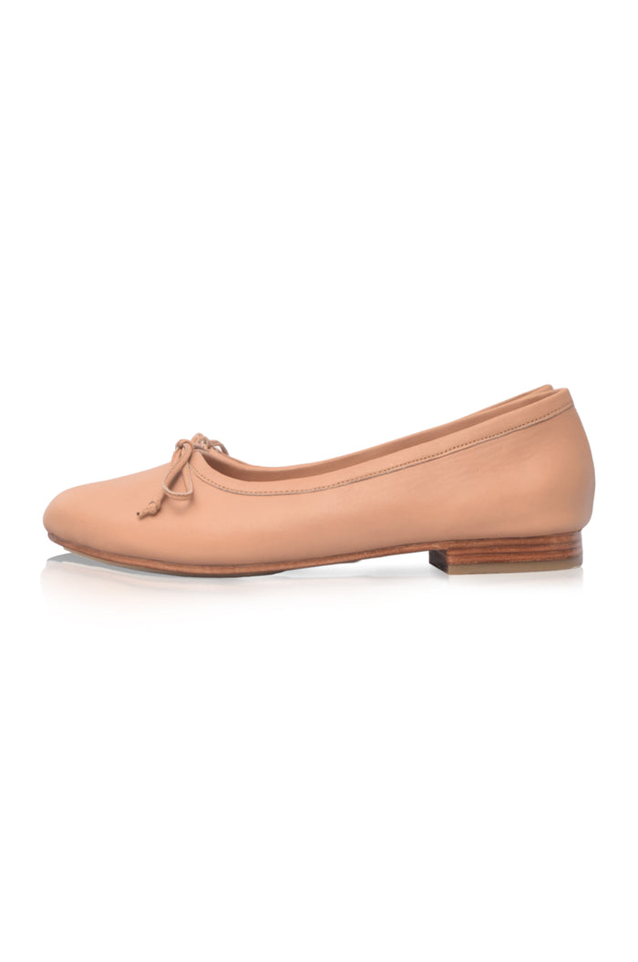 Nude-colored flat shoe on a white background