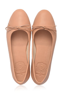 Pair of tan flat shoes with bow details on a white background