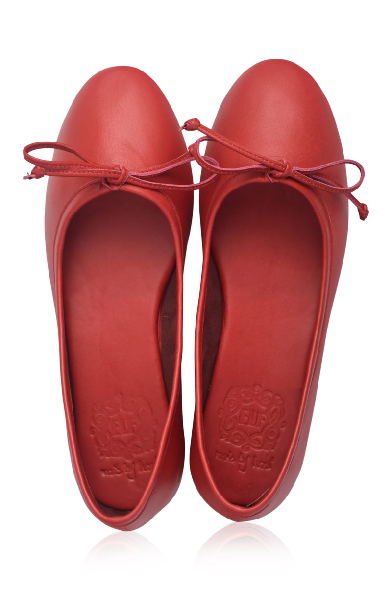 Pair of red shoes with a bow on a white background