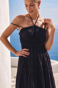 Woman wearing a black dress with a scenic background