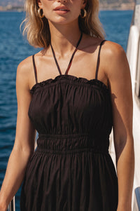 Woman wearing a black dress with a scenic background
