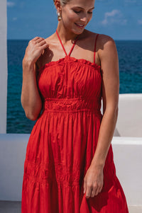Woman in a red dress standing by the ocean