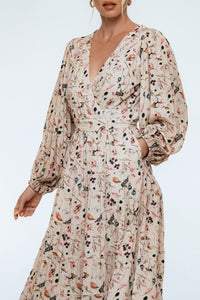 Woman wearing a floral dress with long sleeves on a white background