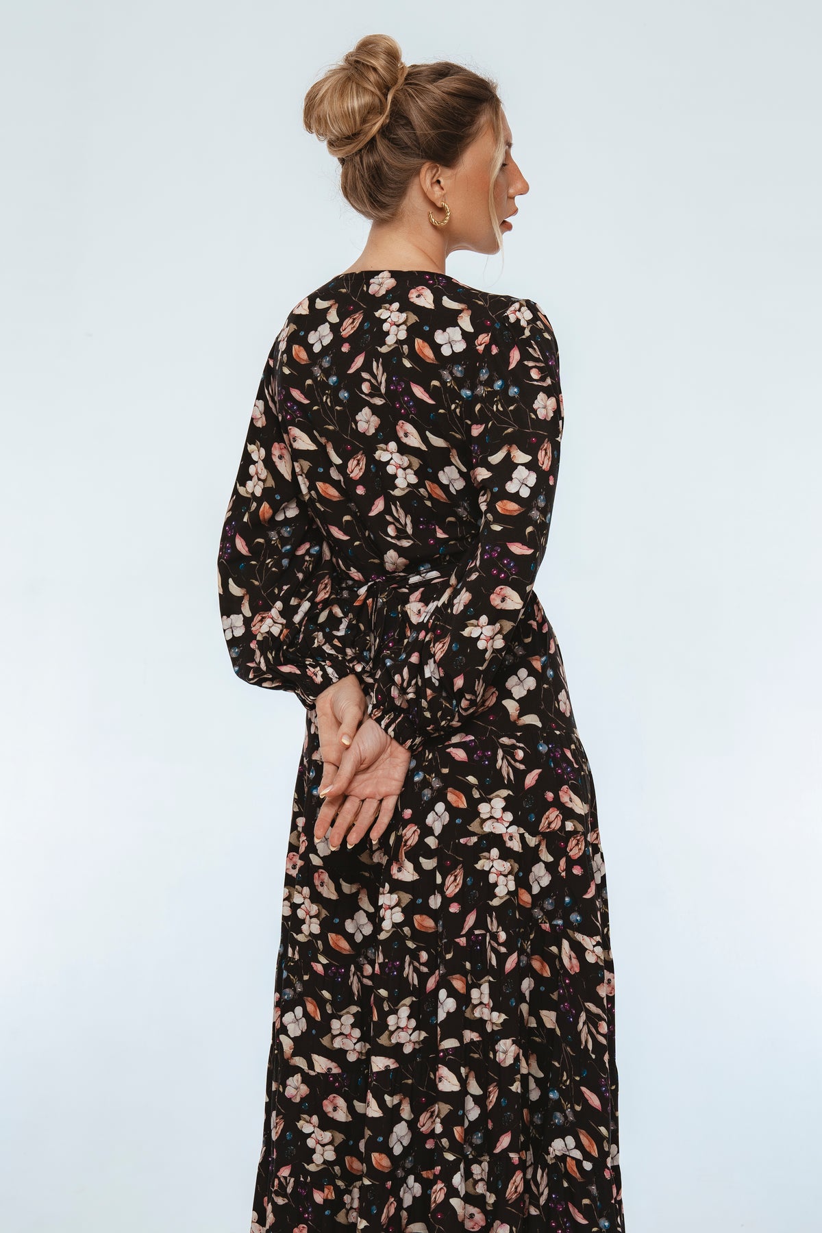 Woman wearing a floral dress against a white background