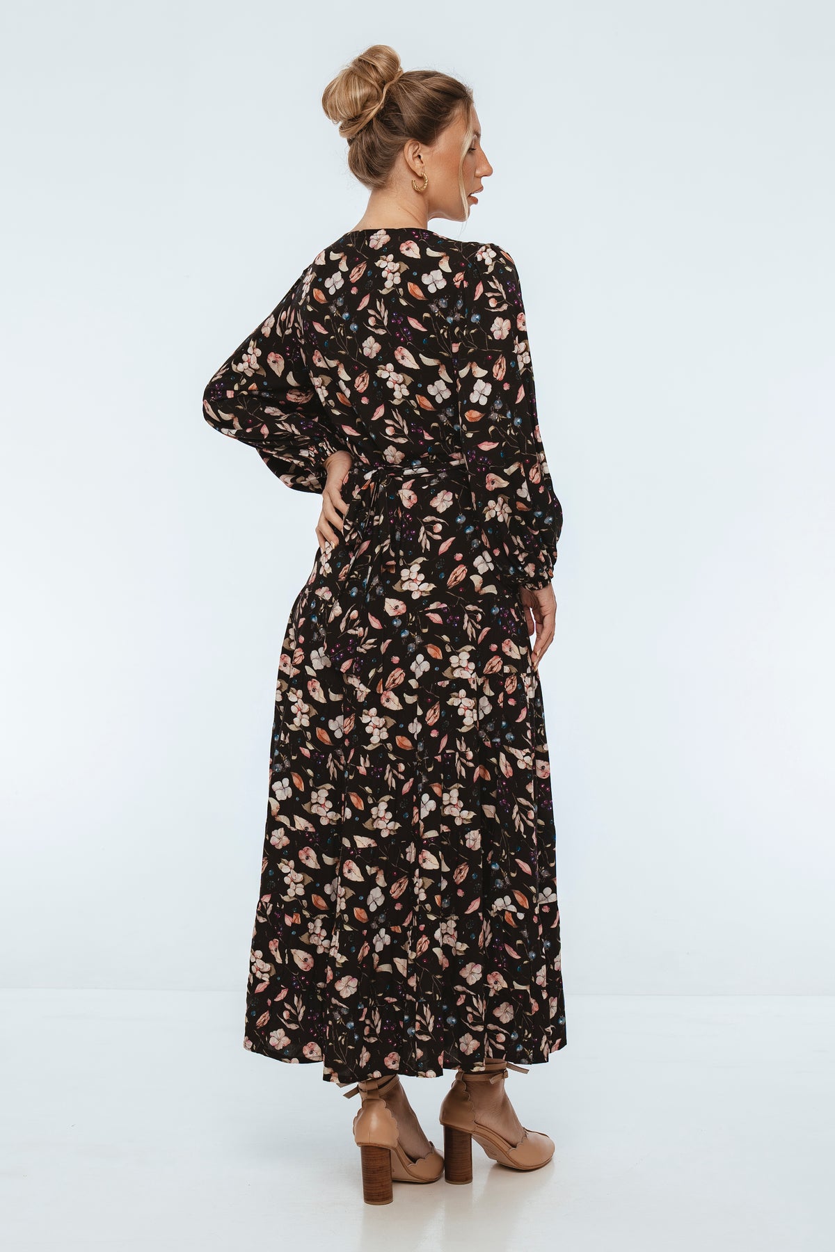 Woman wearing a black floral dress on a white background