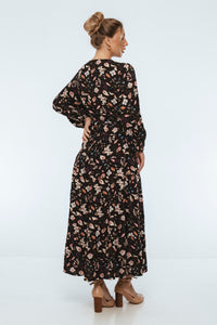 Woman wearing a black floral dress on a white background