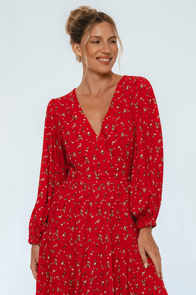 Woman wearing a red dress with a subtle pattern on a white background