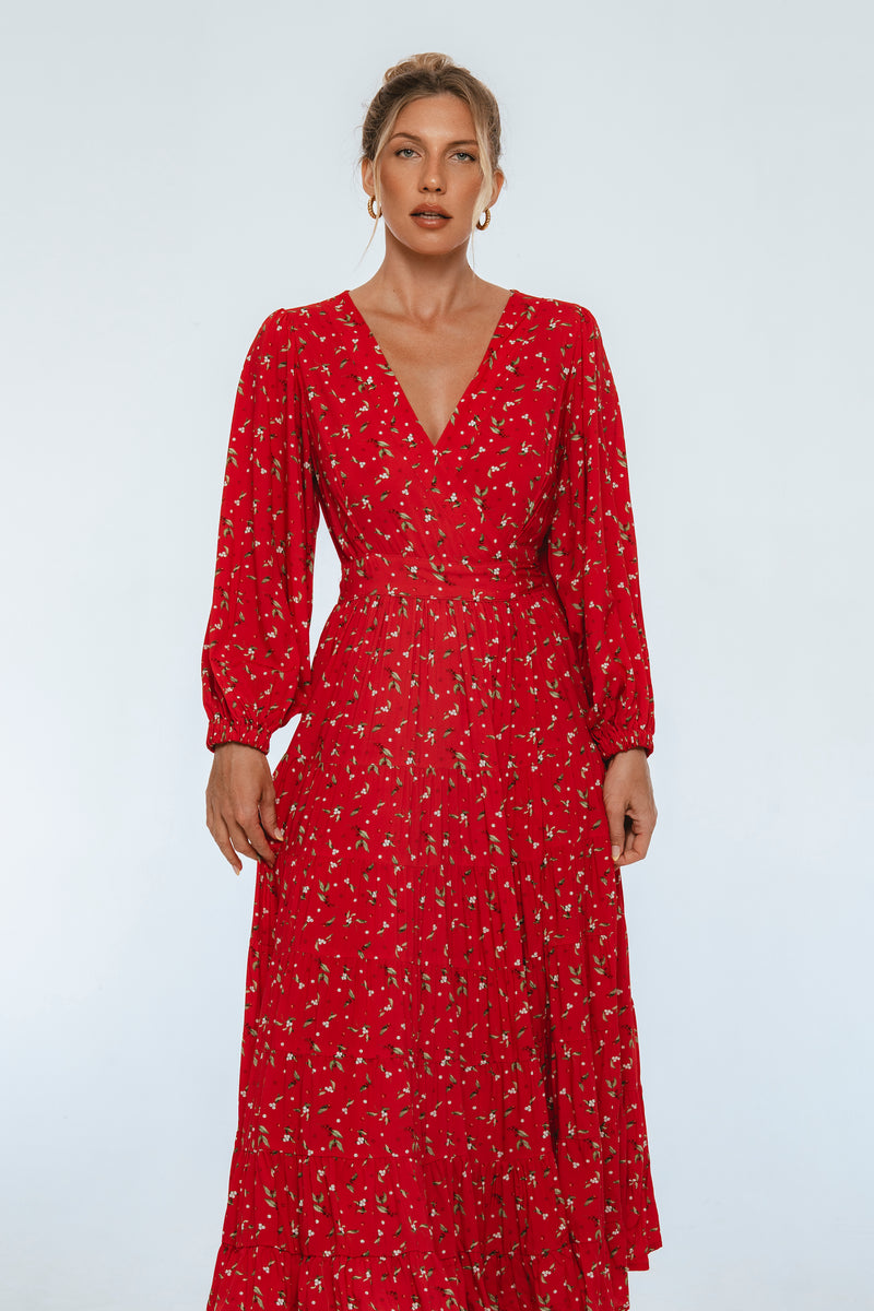 Woman wearing a red dress with a subtle pattern on a white background