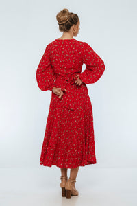 Woman wearing a red dress with a floral pattern on a white background